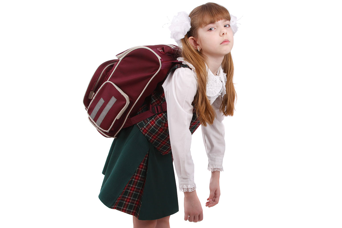 Дочь пришла из школы. Тяжелый портфель школьника. Школьник с тяжелым рюкзаком.